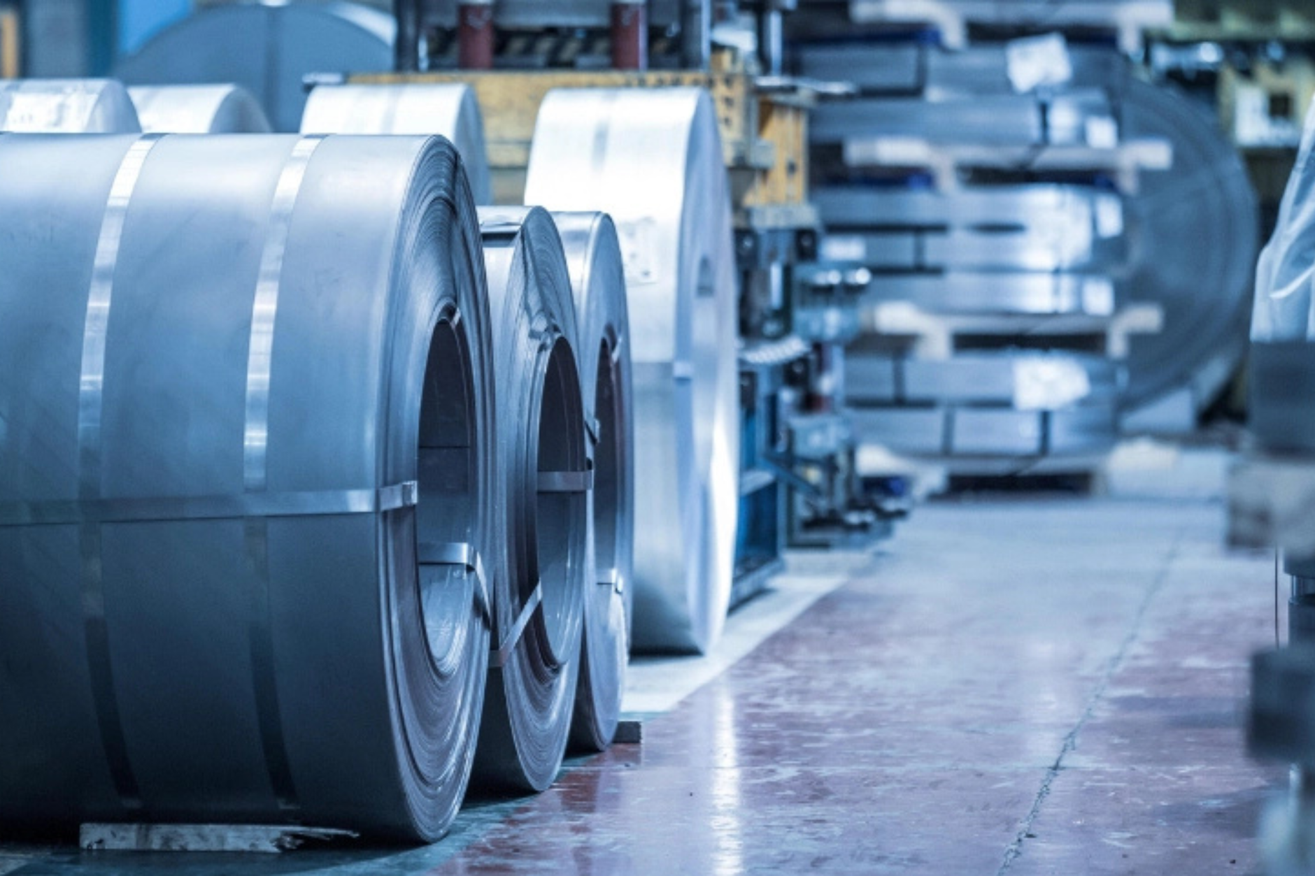 Rows of steel coil stock standing in a bright fabrication plant